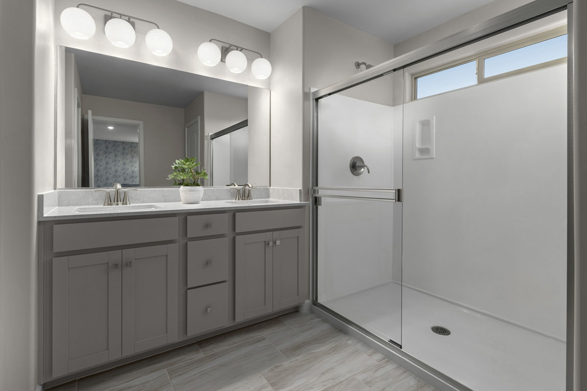 Upgraded walk-in shower with cultured marble surround at primary bath