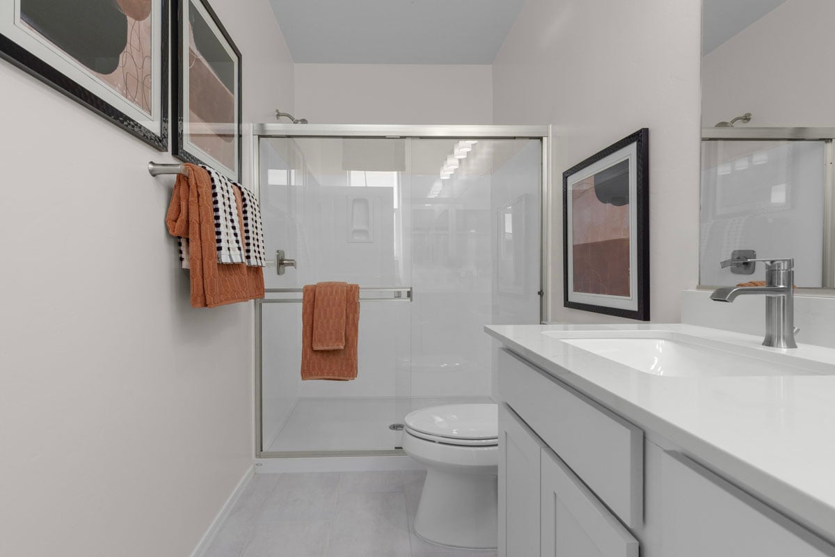 Upgraded shower with cultured marble surround at primary bath