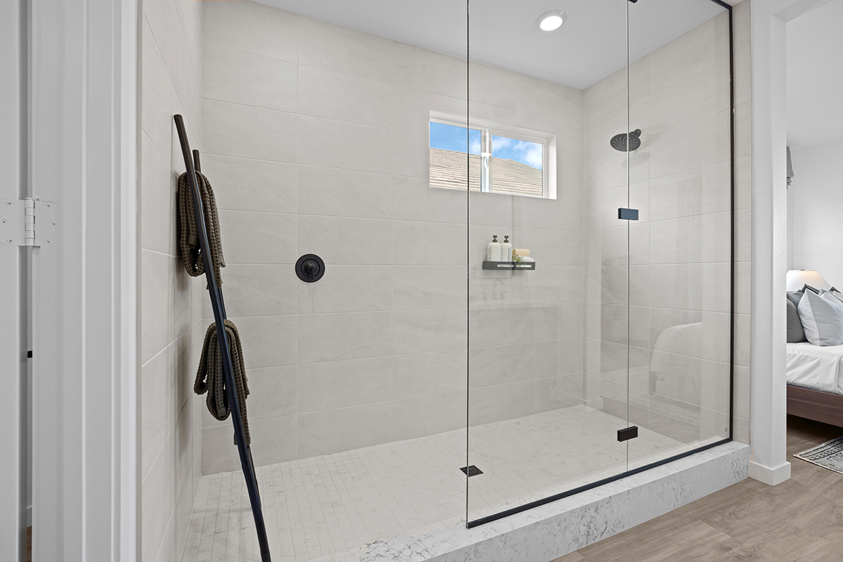 Extended walk-in shower with custom tile at primary bath
