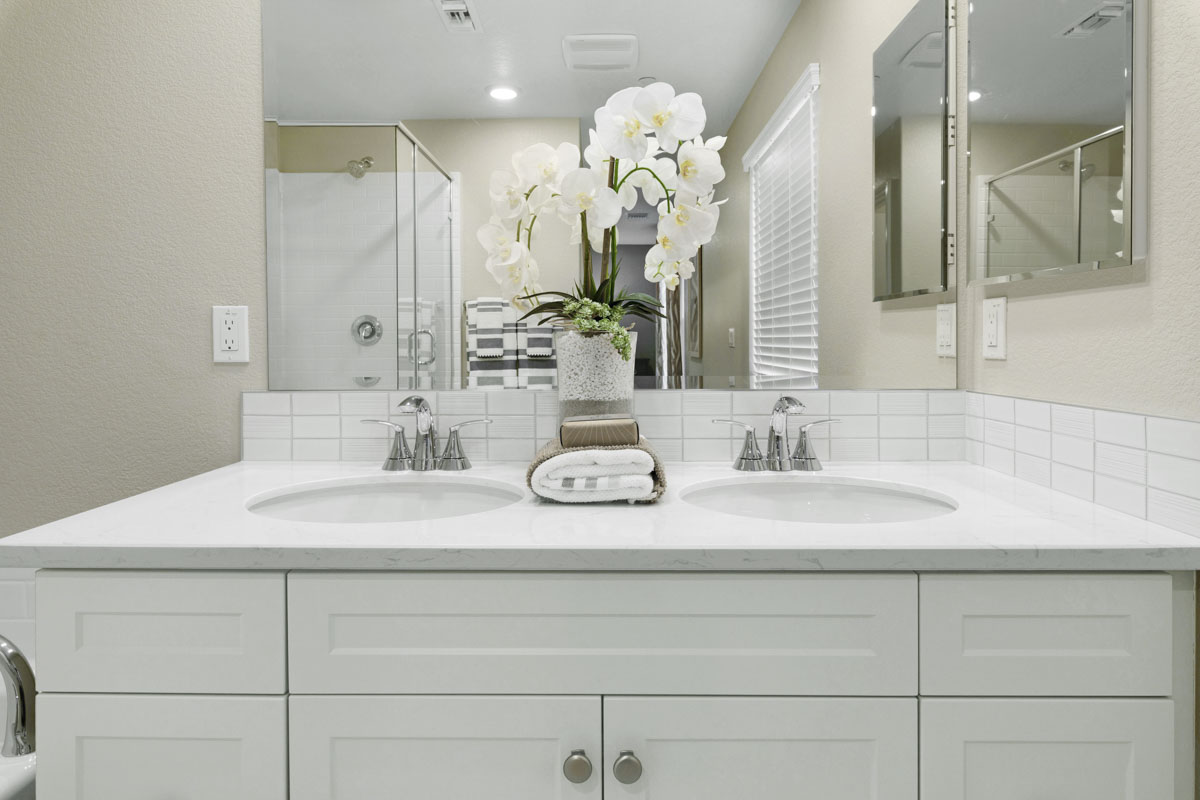 Included e-stone countertop with custom tile backsplash at primary bathroom