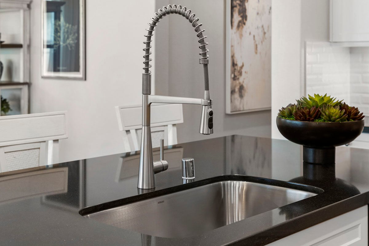 Upgraded single basin sink and drop down faucet at kitchen