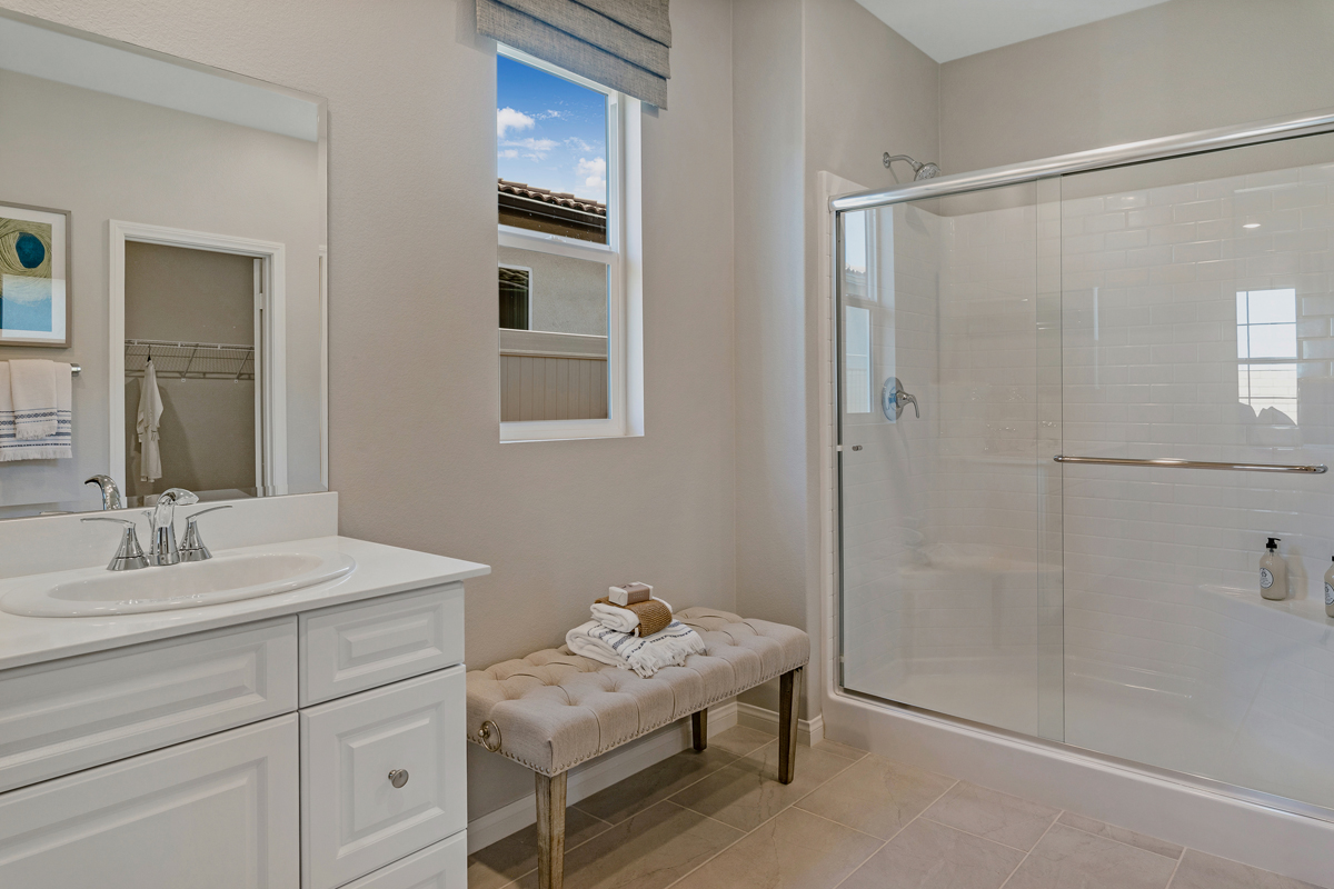 Walk-in shower with clear glass enclosure at primary bath