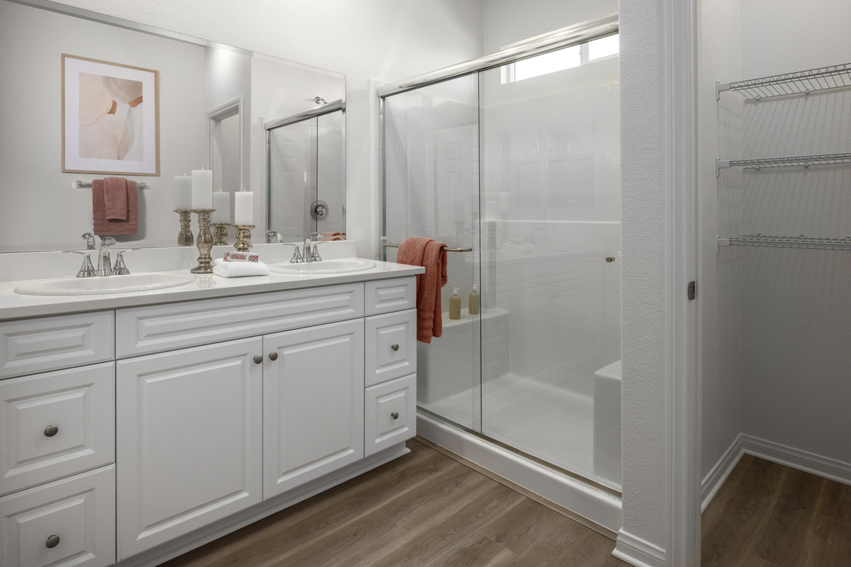 Walk-in shower with clear glass enclosure at primary bath