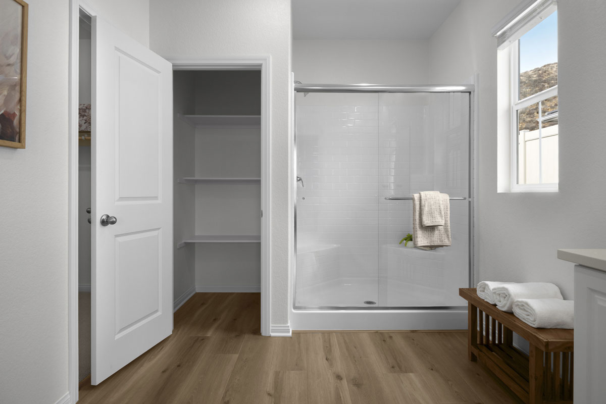 Walk-in shower and linen closet at primary bath