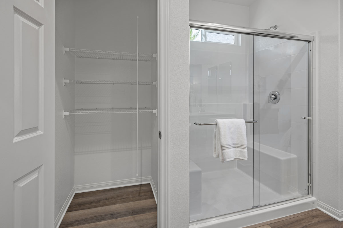 Walk-in shower and linen closet at primary bath