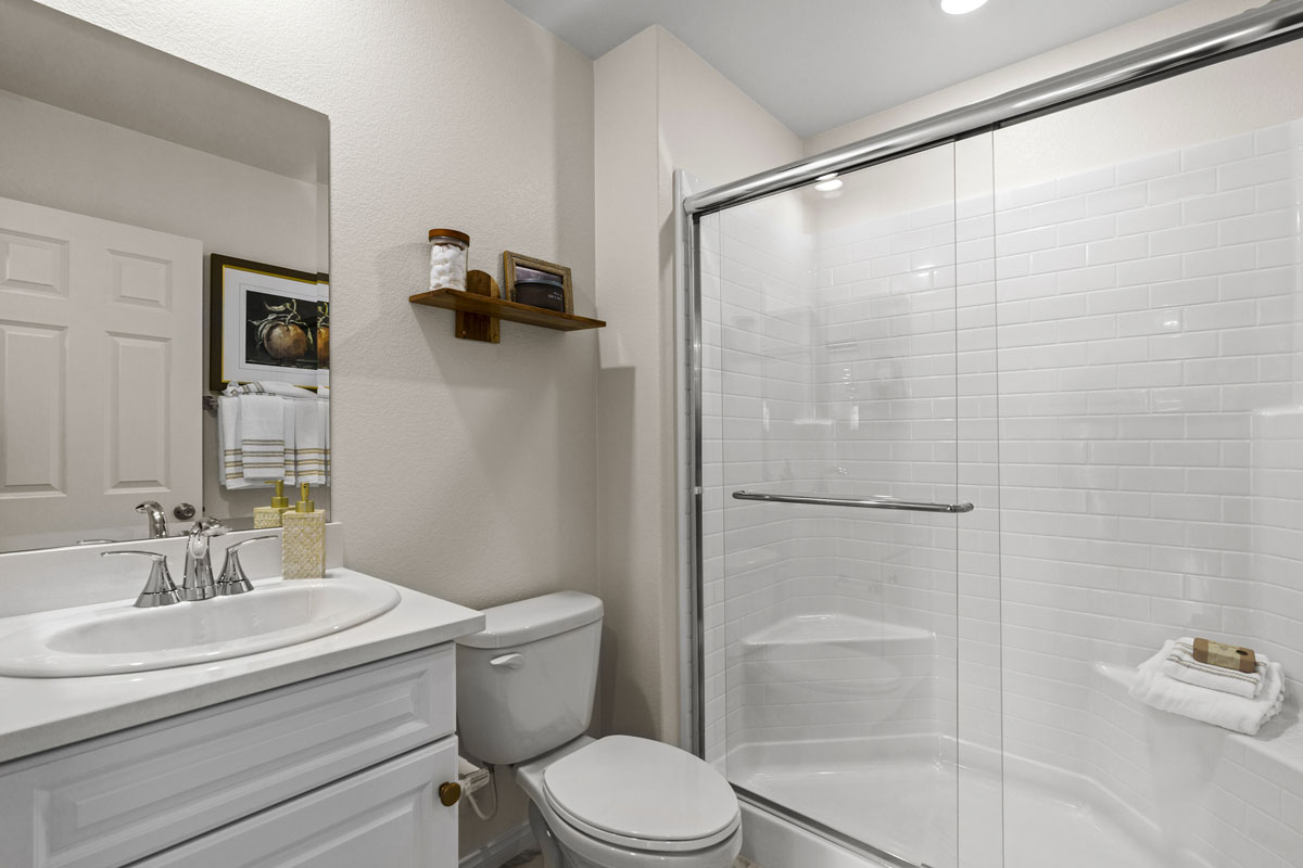 Walk-in shower with clear glass enclosure at primary bath