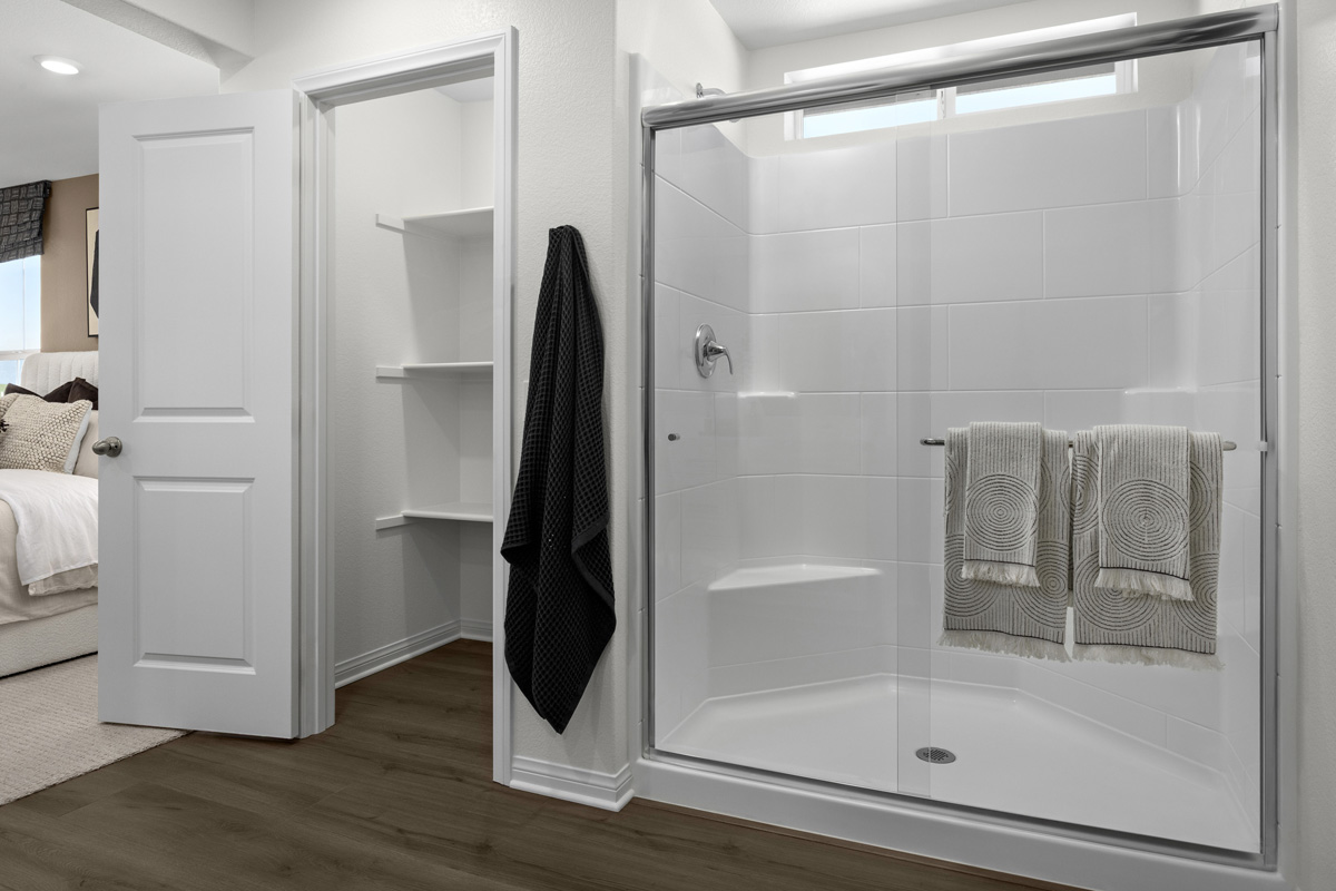 Walk-in shower and linen closet at primary bath