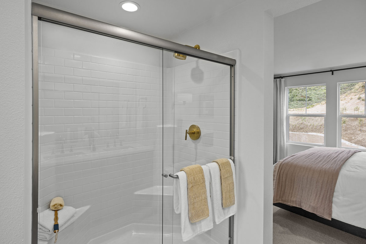 Walk-in shower with clear glass enclosure at primary bath