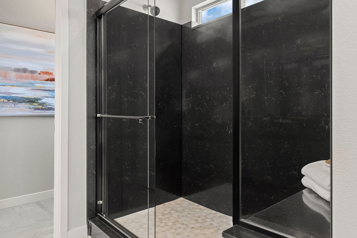 Enlarged shower with seat and quartz surround at primary bath