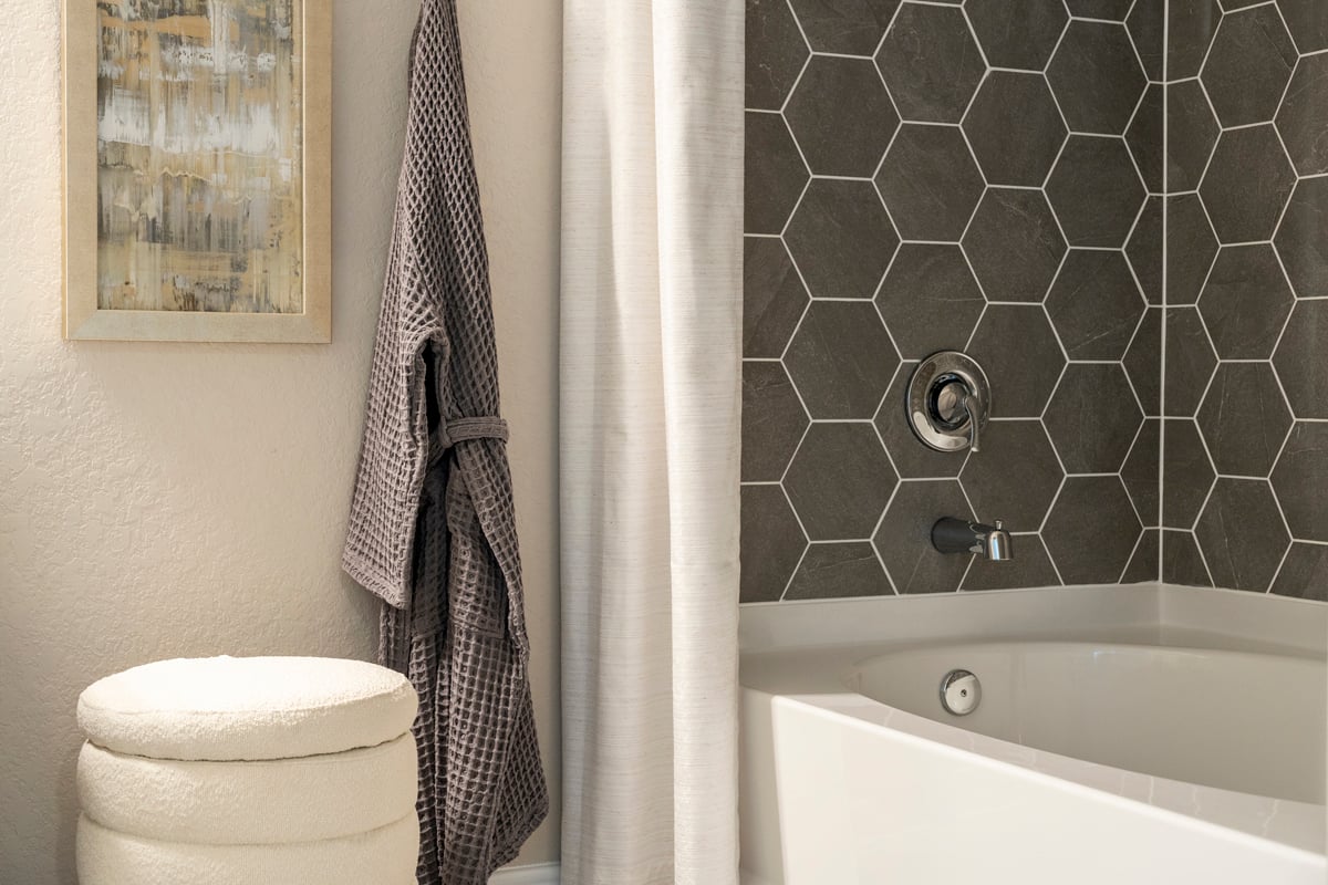 Garden tub with hexagon tile surround at primary bath