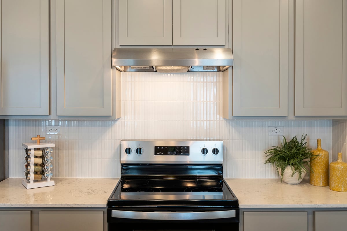 Glossy quartz countertops with vertical tile backsplash