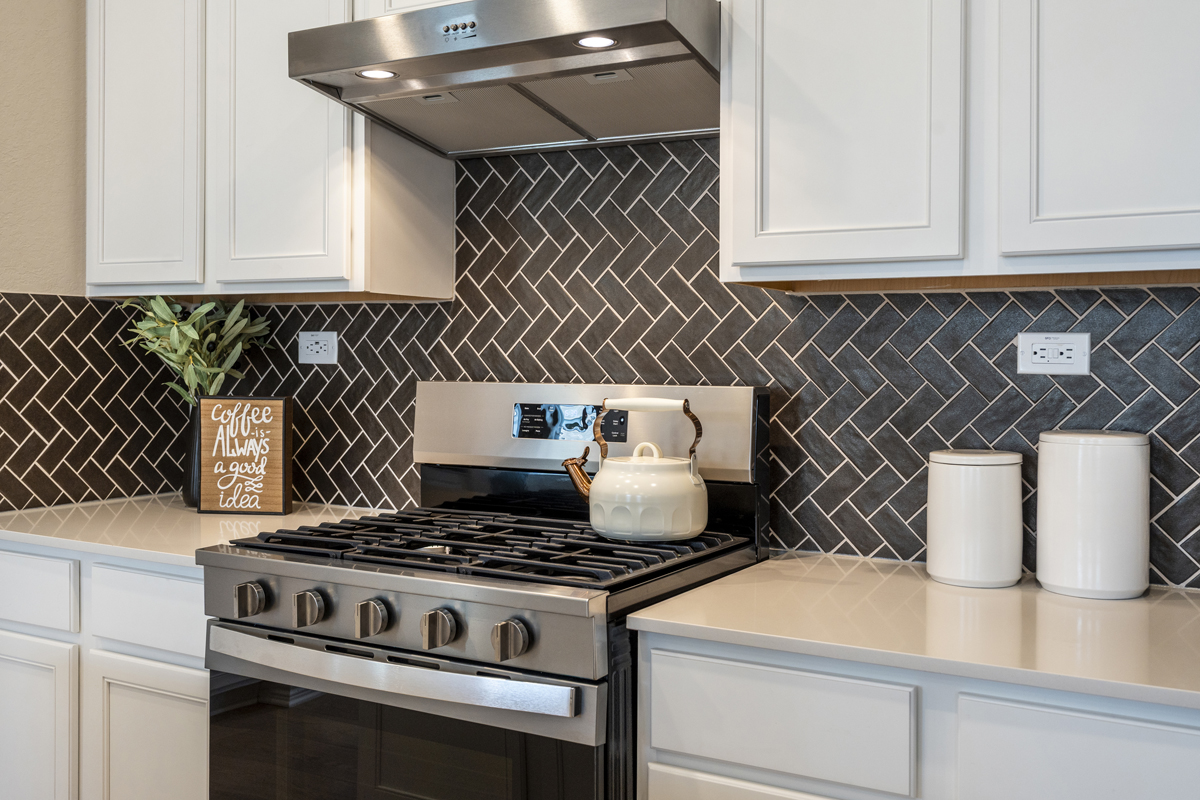 Glossy tile backsplash in herringbone pattern